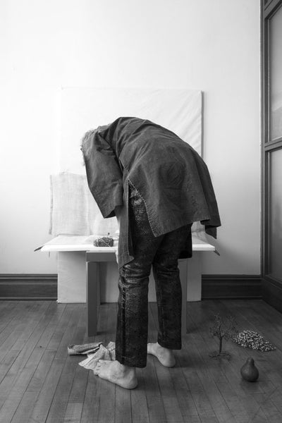 Andrea Aranow leans over a low table in her studio 