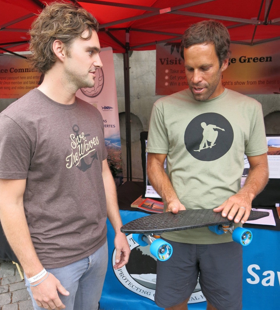 Bureo co-founder Ben Kneppers hands Jack a skateboard prototype at his 2014 concert in Santiago, Chile