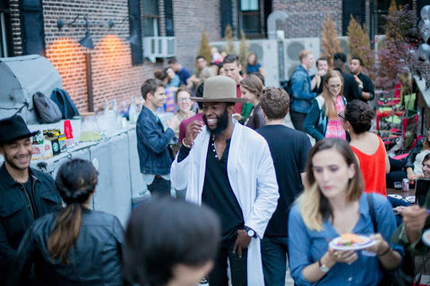 Guests laughing, eating and drinking on a super cool NYC rooftop party in SOHO.