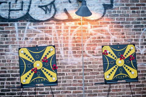Two KOOBA game boards lined up against graffitied wall at sunset for party guests to play on SOHO rooftop in New York City.  