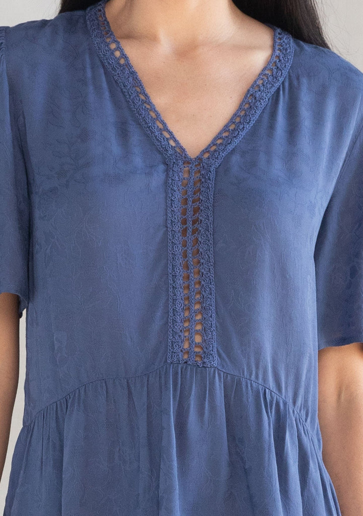 [Color: Indigo Blue] A model wearing a flowy indigo blue short sleeve top. 