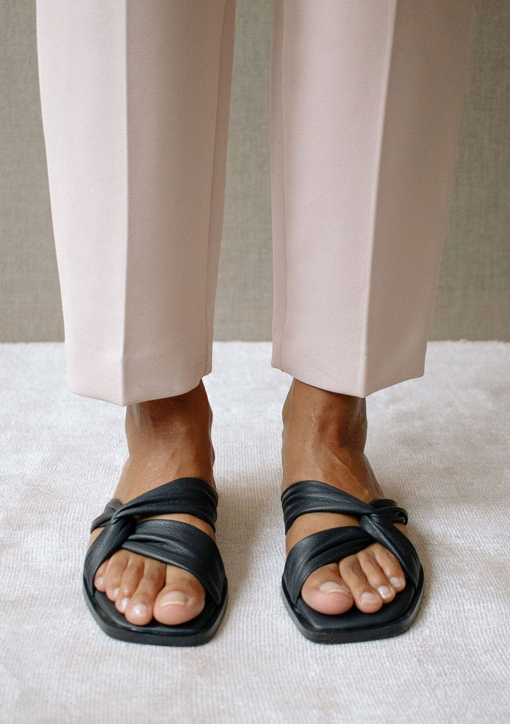 [Color: Black] Alohas nomad black leather flat sandal with a knotted front strap and square toe. 