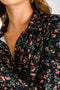 Blusa corta de estampado floral, manga larga, fit ajustado, cuello camisero y plisado frontal con hilera de botones.