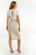 Falda midi de fit ajustado, cintura alta con pretina elástica y detalle lateral de abertura cut out.