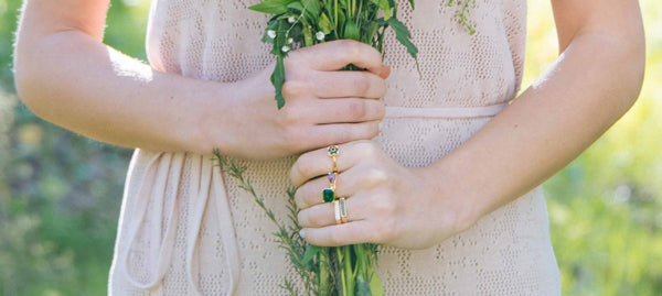 girl holding fowers in a field jewelry by hot crown