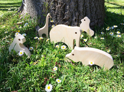 Animales de madera de la marca chinpum, en un cesped verde del parque.