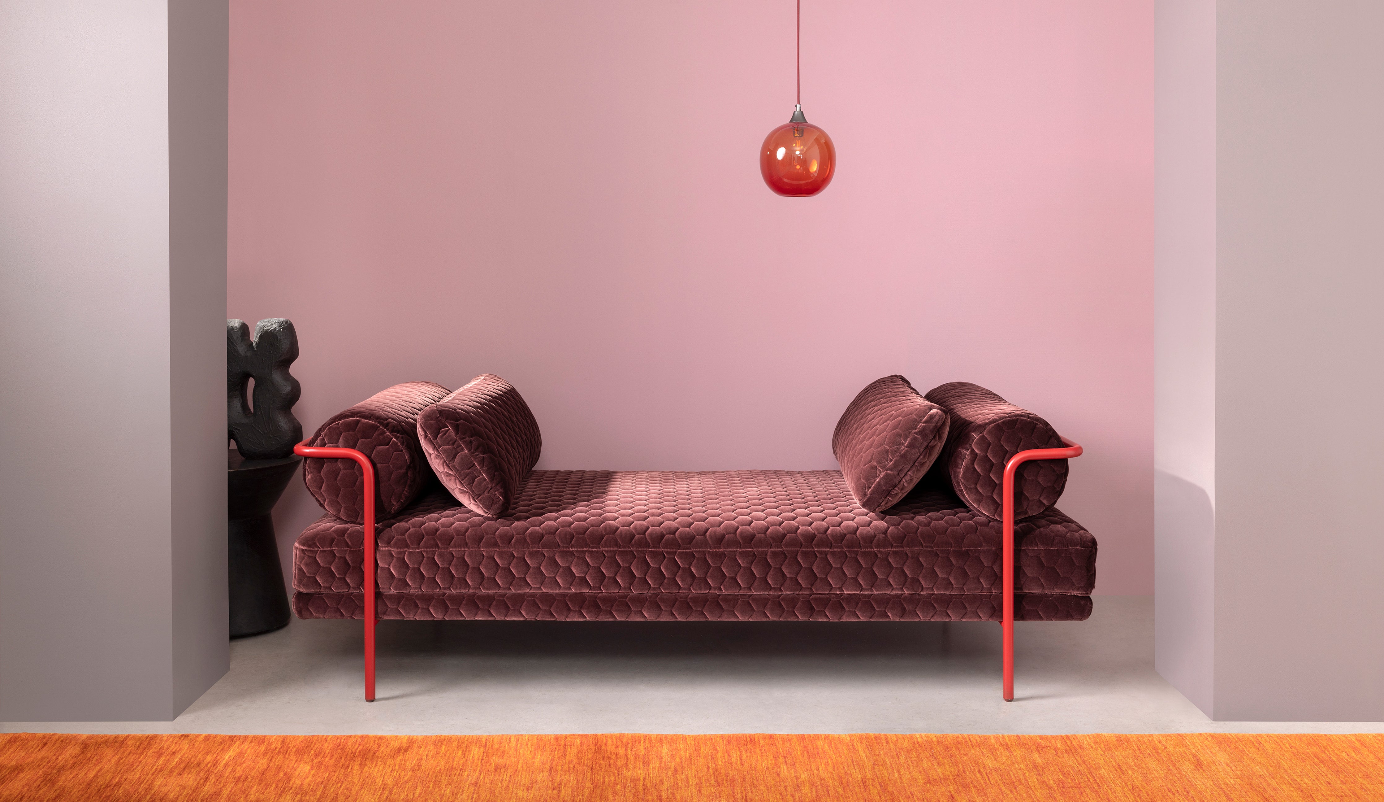 Sofa in geometric velvet fabric by Kirby Design with pendant light in cherry red glass by Rothschild &amp; Bickers 