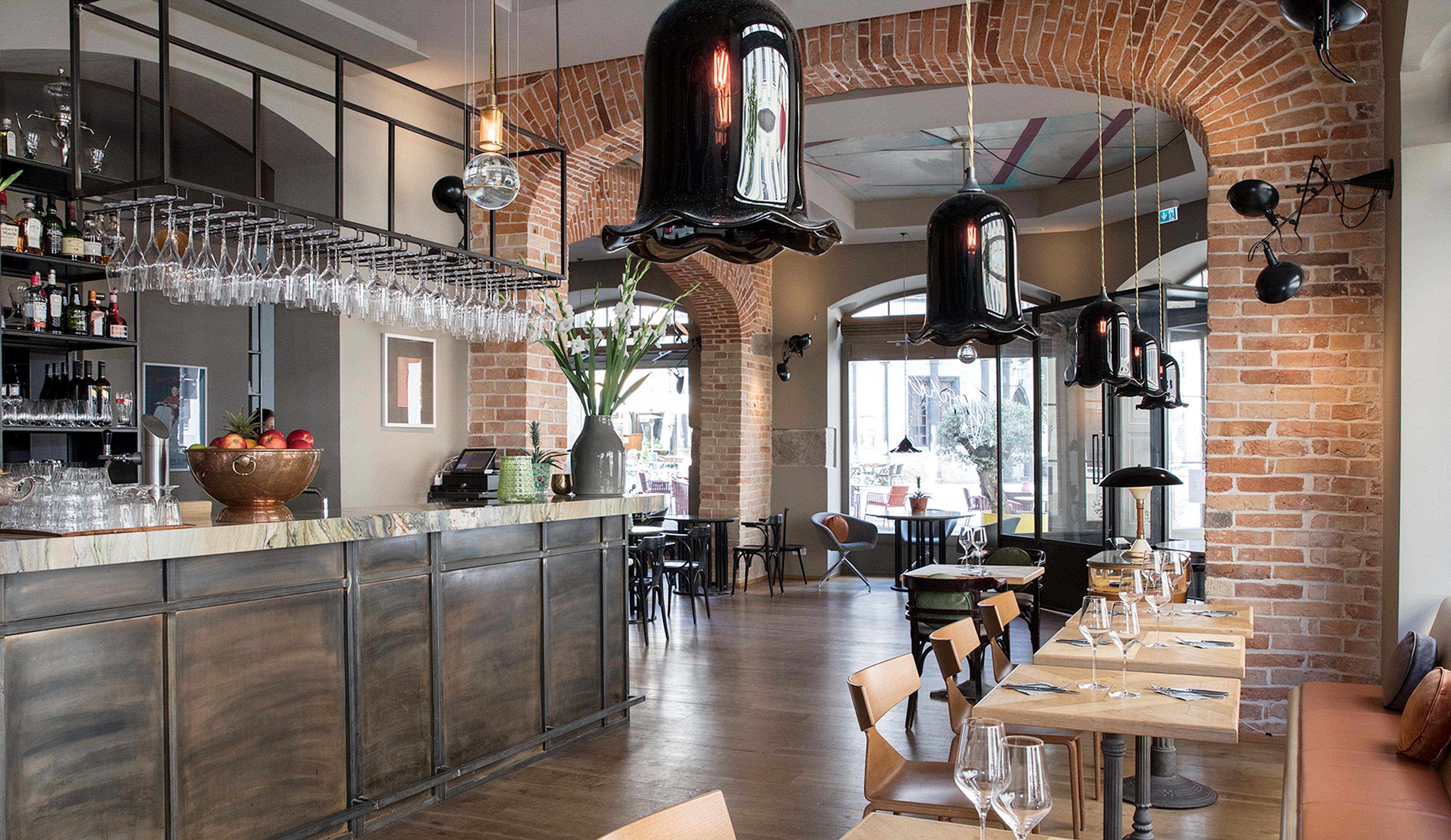 Nouveau bell pendants by Rothschild &amp; Bickers hanging over tables at Restaurant Horschel