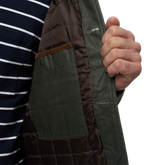  closeup of a man wearing spruce Men&#39;s Field Coat with Sherpa Collar front view showing left inside pocket

