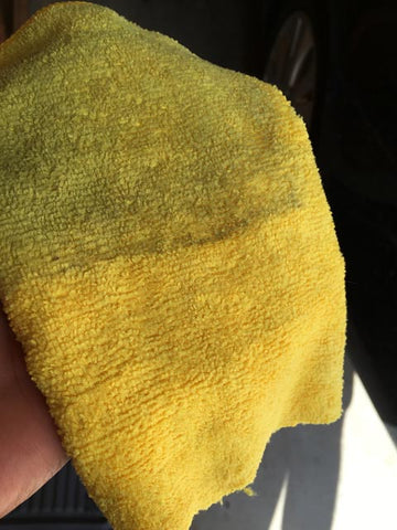 half clean, half dirty yellow microfiber towel in hand