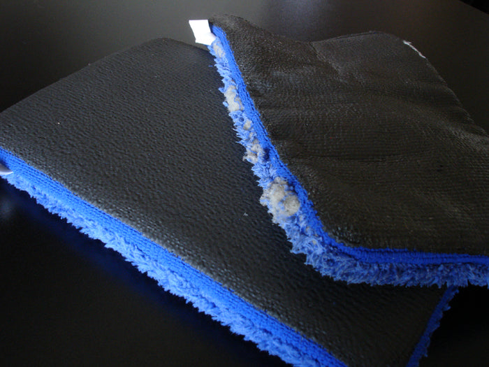 A comparison photo showing new blue fine grade Kleanmitt beneath an old, weathered blue fine grade Kleanmitt