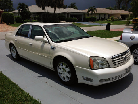 A clean and detailed exterior photo of a pearl white 2005 Cadillac Deville