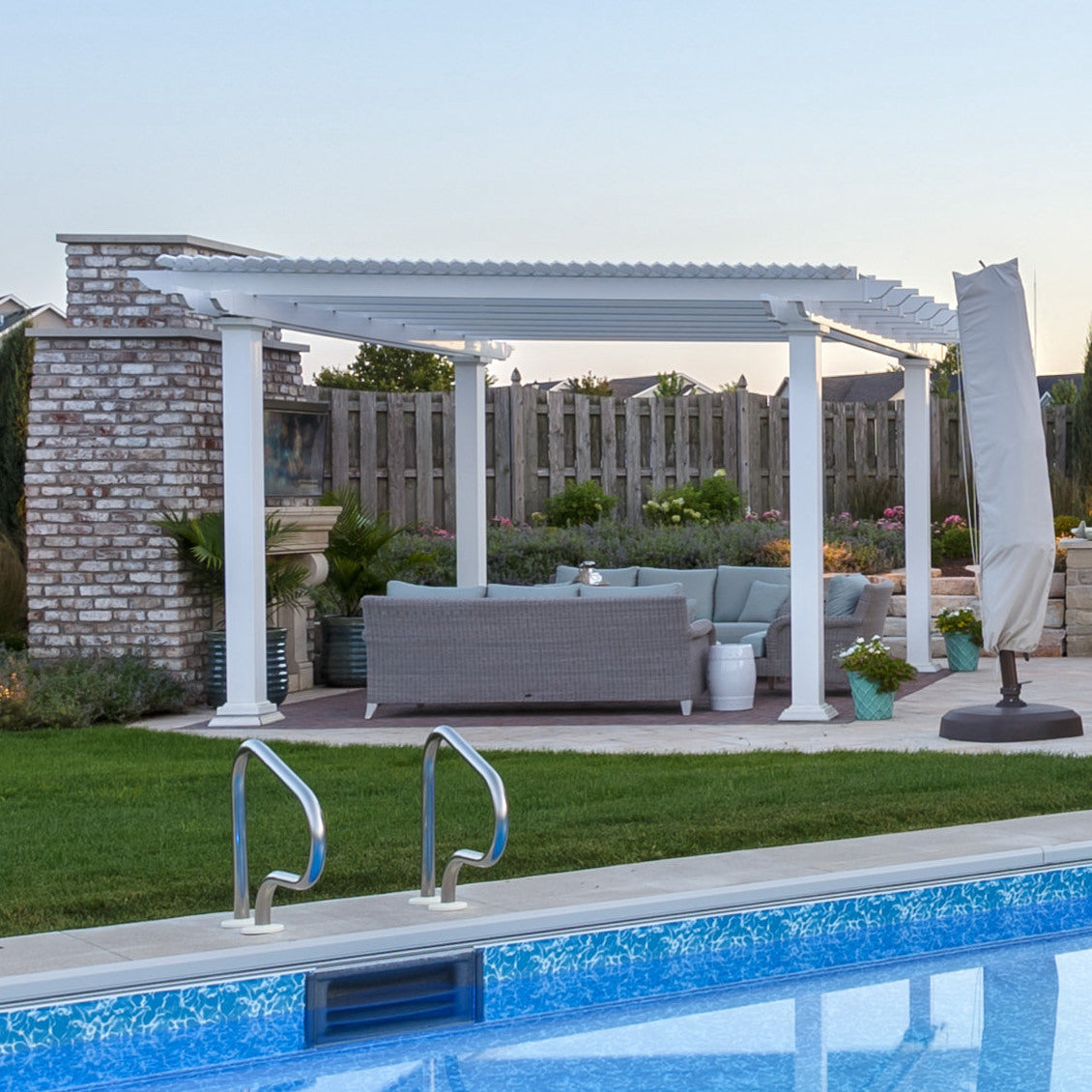 Picture of a stand-alone white vinyl pergola with 4 posts next to a swimming pool