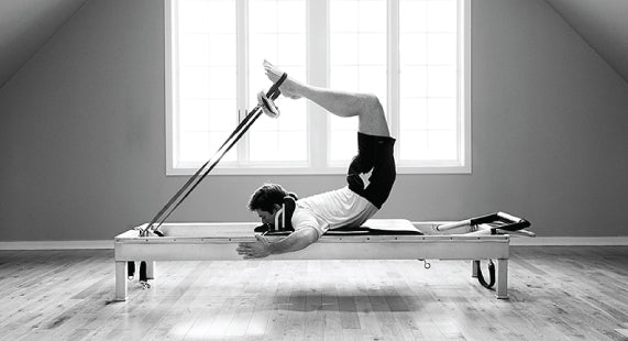 Gratz Gallery | Michael Johnson performing the Scorpion exercise on the Universal Reformer