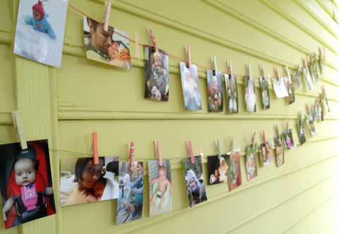 Washi tape decorated clothes pins on photo wall first birthday activity