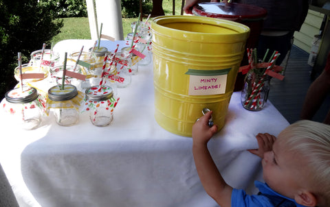 Mason jars with cloth covers and paper straws for minty limeade drink