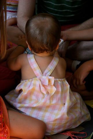 pink yellow gingham party dress with bow on one year old girl