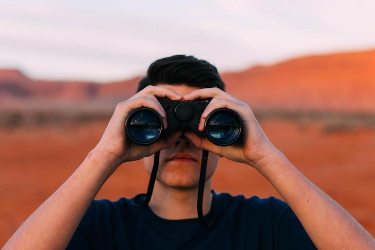 design process: man looking through binoculars