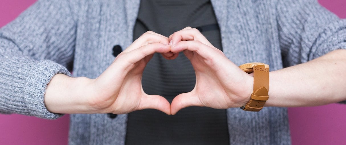 Person holding hands together, making the shape of a heart.