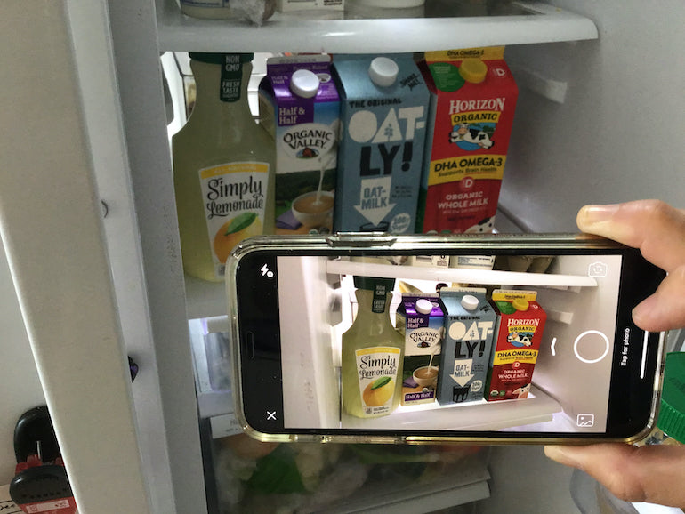 user research: person taking a picture of drink cartons in their fridge