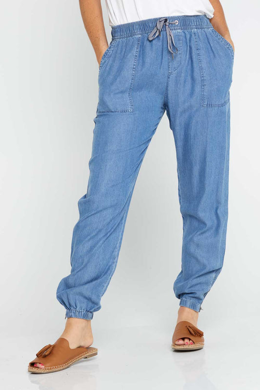 Washed blue chambray pants with elasticated waistband and cuffs with small zips at the ankles
