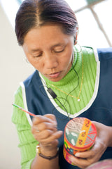 Artisan at Kapula hand painting candles