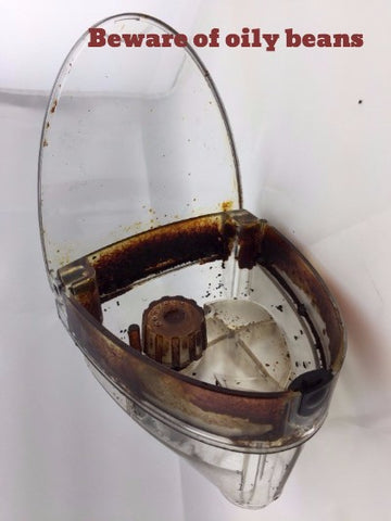 Bean hopper in a superautomatic espresso machine that has oily residue left behind from the coffee beans
