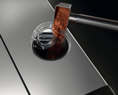 Ground Coffee being placed in bypass hopper of a superautomatic espresso machine