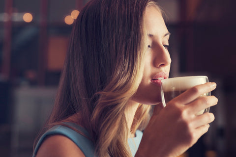 Women drinking a cappuccino made from ta Saeco Xelsis