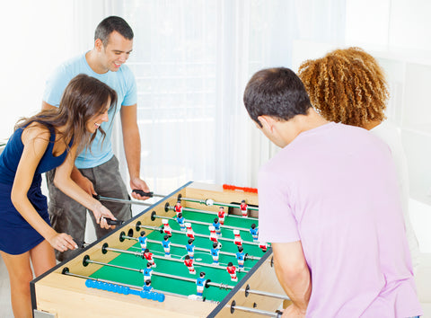 Family playing at a Garlando G-5000 foosball table at home.