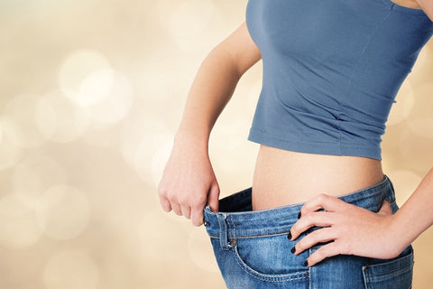 Woman in overly large jeans showing weight loss