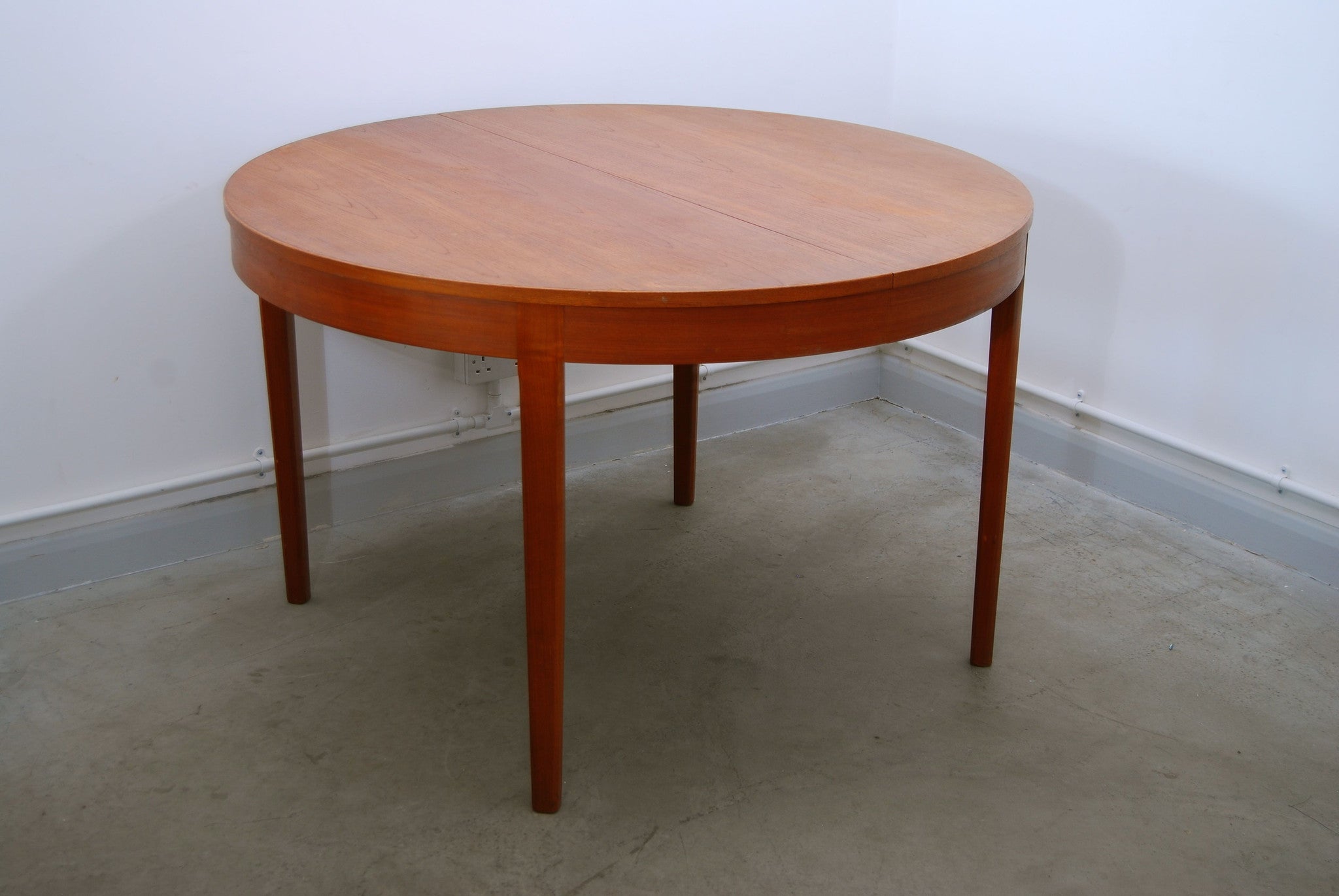 Round extending dining table in teak