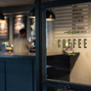 An image showing the interior of the Mutt Motorcycles coffee shop, showing a door graphic of the word 'Coffee'