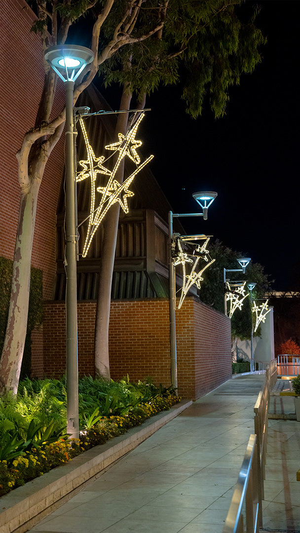 A close-up photo of lined up starburst light pole décor, showcasing its intricate design and warm light.