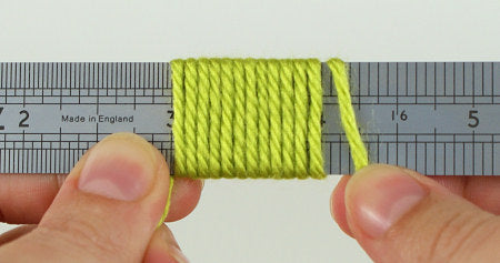 demonstrating wraps per inch, WPI in yarn