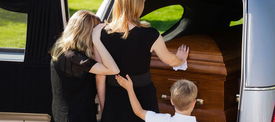 Mother With Two Young Children Seen From Behind Placing Hands on Casket