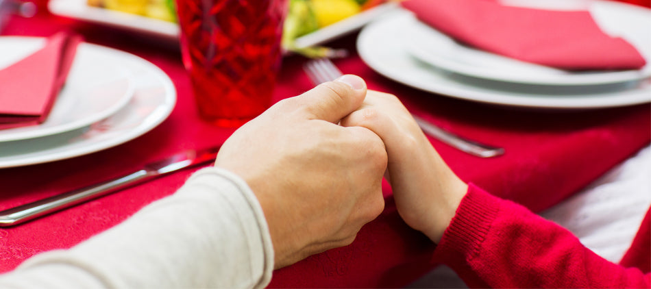 Two People Holding Hands at Holiday Table
