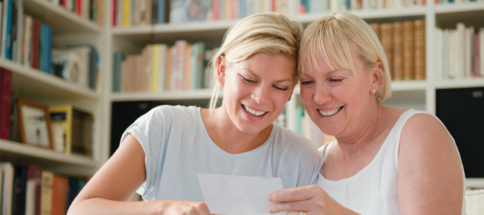 Two ladies smiling looking at a piece of paper