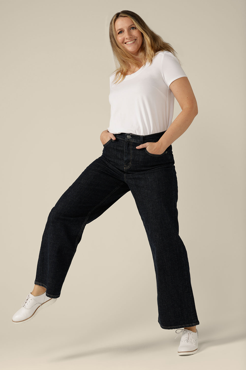 High-waisted, flared leg jeans in midnight denim, size 12. Ethically and sustainably made by Australian and New Zealand women's clothing label, L&F, these tailored jeans are worn with a white bamboo top.