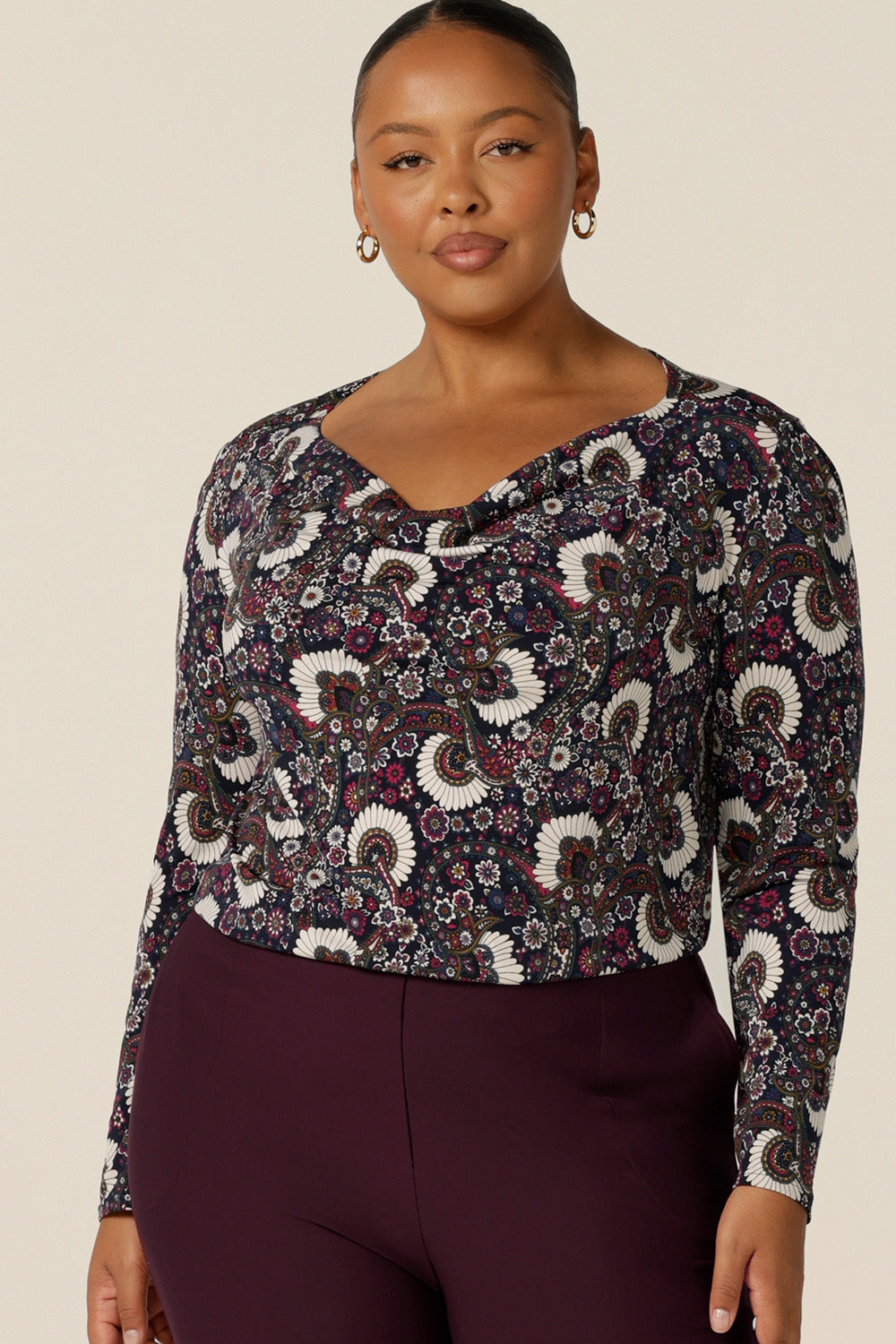 a plus size woman wears a long sleeve, cowl neck top in paisley print jersey, size 18. A great work top, the Chrissy Top is made in Australia by Australian and New Zealand women's clothing label, L&F and is available to shop in top sizes 8 to 24. 