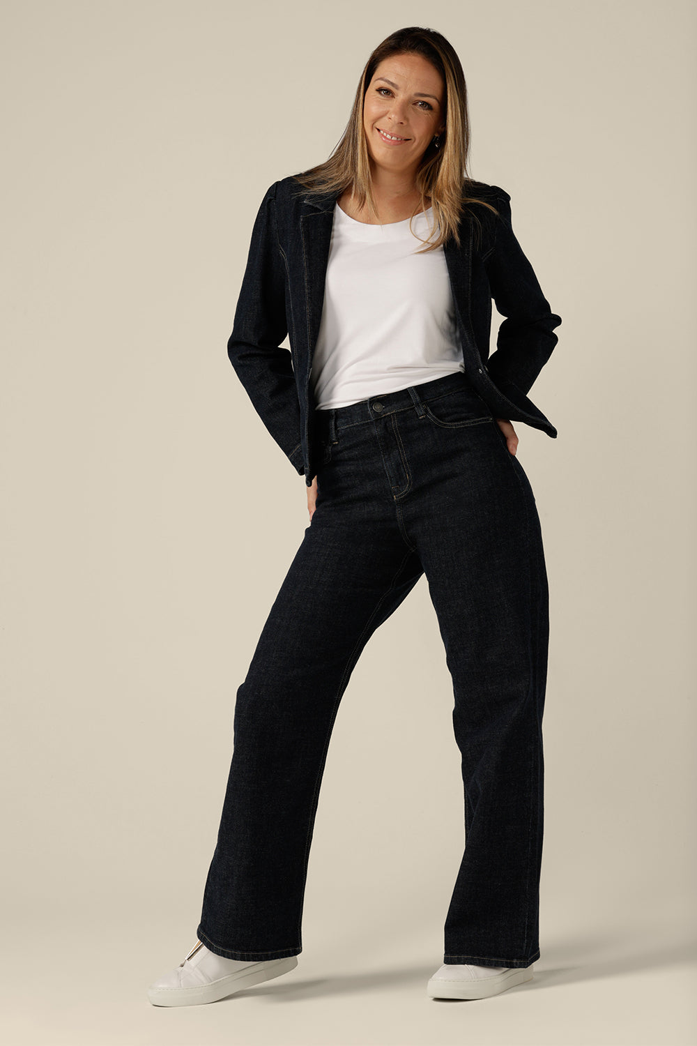 High-waisted, flared leg jeans in midnight denim, size 8 worn with a white bamboo jersey top and denim jacket. Ethically and sustainably made by Australian and New Zealand women's clothing brand, L&F, and available to shop in an inclusive size range of 8 to 24.