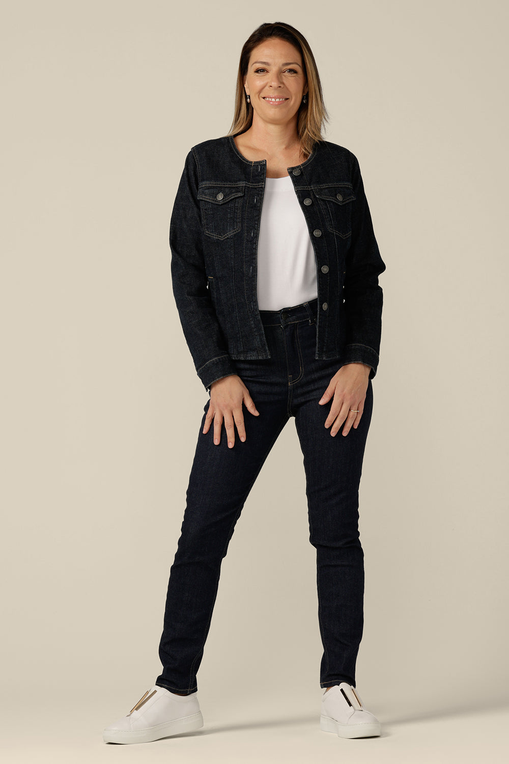 A collarless denim jacket in size 8 is worn with white bamboo jersey T-shirt and super-stretch skinny jeans. Ethical and sustainable, and made in partnership with Outland Denim, this denim jacket is tailored to fit women in sizes 8 to 24 by Australian and New Zealand women's clothing label, L&F.