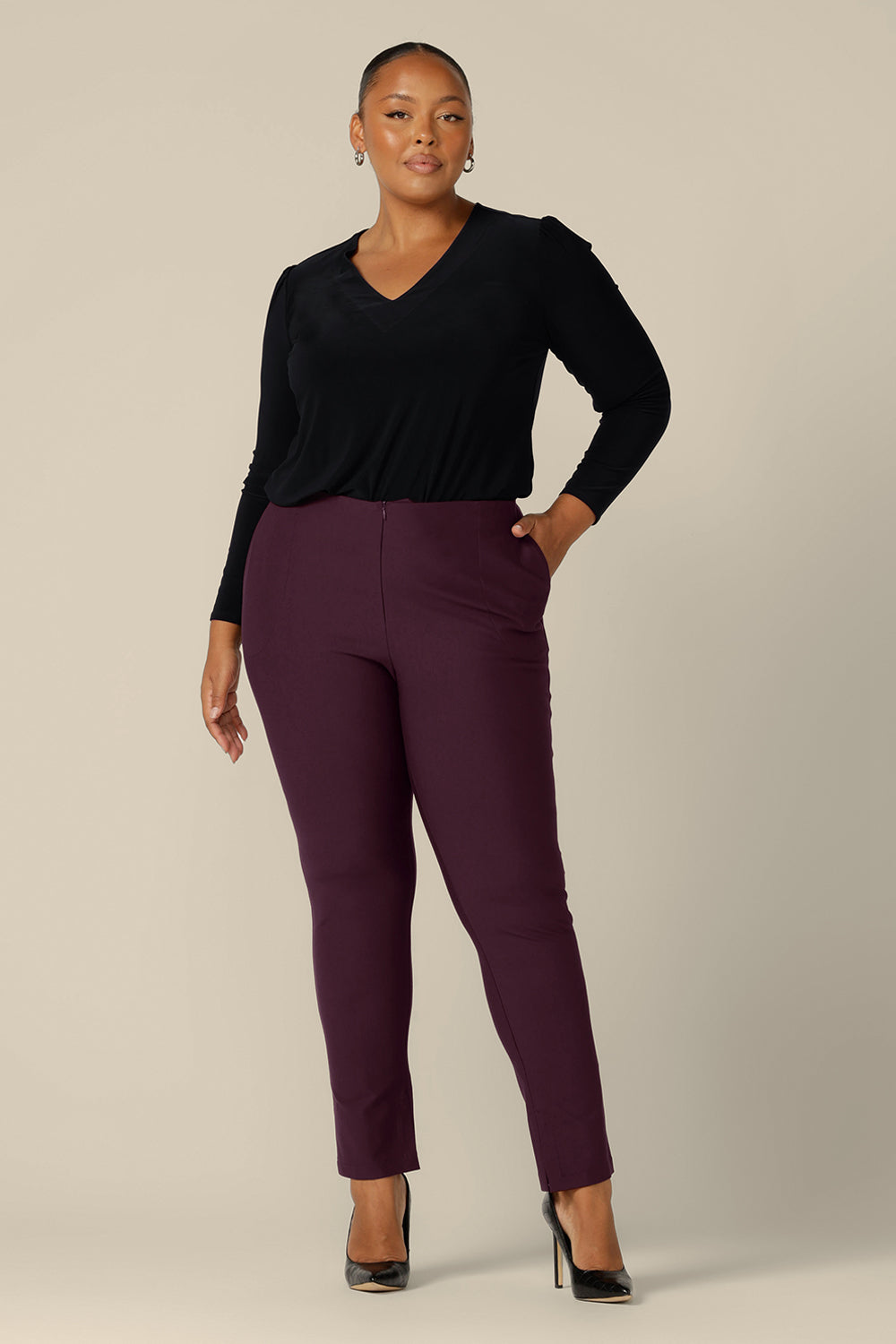 A size 18, fuller figure woman wears slim leg pants in mulberry ponte jersey by Australia and New Zealand women's clothing brand, L&F. Good pants for work, these comfortable trousers are worn with a long sleeve, V-neck top in black jersey.