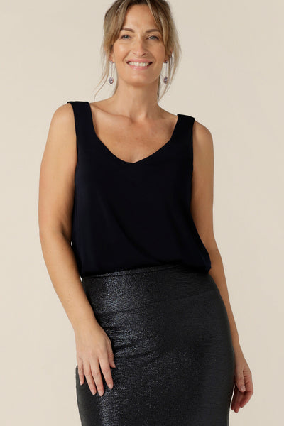 A size 10, 40 plus woman wears a navy cami top with wide shoulder straps. Made in Australia by Australian and New Zealand women's clothing company, this slinky jersey top wears well with evening and occasionwear skirts, pants and suit jackets.