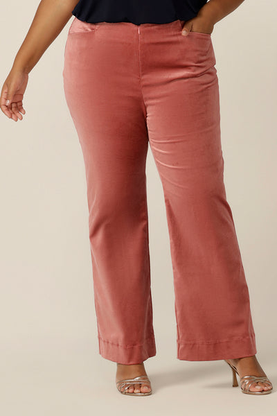 Evening and special event wear for plus size women gets a touch of disco fever with these flared leg, tailored pants in musk pink velveteen. Worn with a slinky navy blue cami top for evening wear, these cocktail dress pants are made in Australia in sizes 8 to 24, petite to plus sizes.