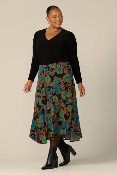 An asymmetric, midi skirt by Australian and New Zealand women's clothing brand, L&F. The Germaine Skirt in floral 'Secret Garden' print jersey is worn with a long sleeve, V-neck top in black jersey. Made in Australia, this modern skirt style is available in an inclusive 8 to 24 size range.  