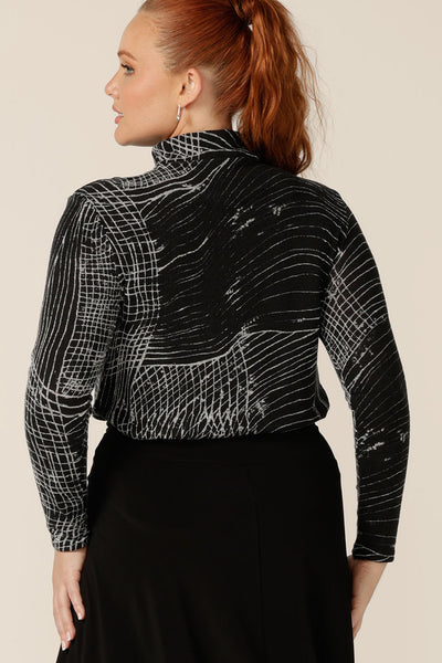 Back view of a curvy woman wearing a long sleeve, woolly knit turtleneck top, size 12, in an abstract black and white pattern by Australian and New Zealand women's clothing label, L&F. A cosy winter top, this women's polo neck top is a textured knit - so looks like wool without the itch of wool! 