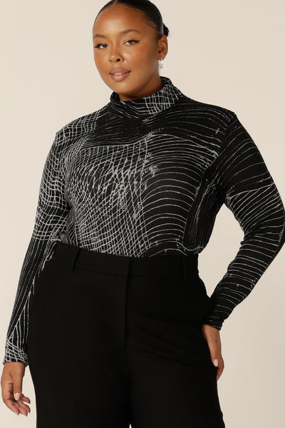 All the warmth of wool without the itch and discomfort, this textured knit top is warm for winter. A fuller figure woman wears a long sleeve, woolly knit turtleneck top, size 18, in an abstract black and white pattern by Australian and New Zealand women's clothing label, L&F.
