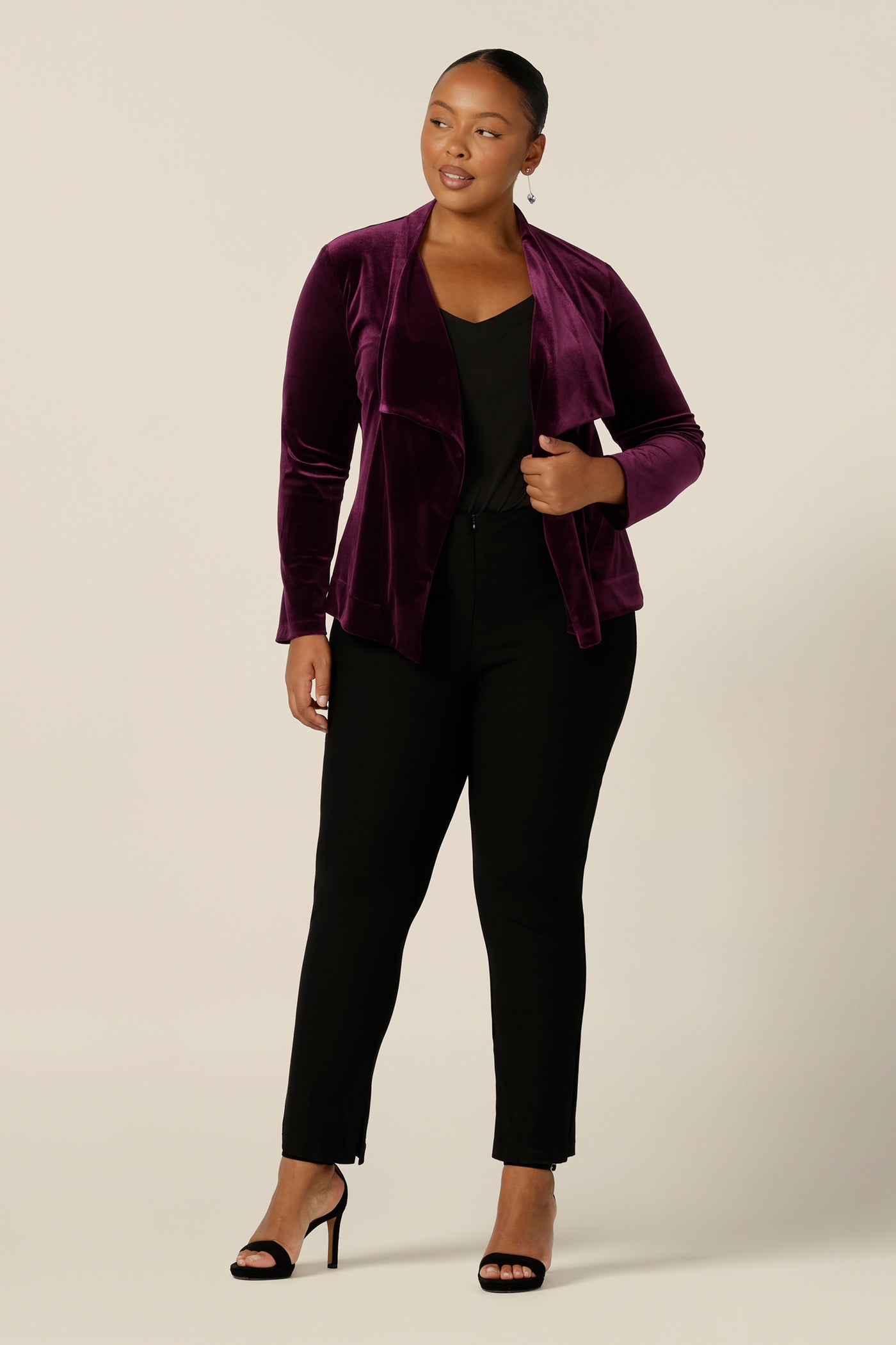 Occasionwear dressing at its finest, this soft tailoring jacket in red wine velour adds effortless glamour to black cocktail wear. Shown here over a black cami top and slim leg black trousers, this open front, soft collared evening jacket is made in Australia in sizes 8 to 24.