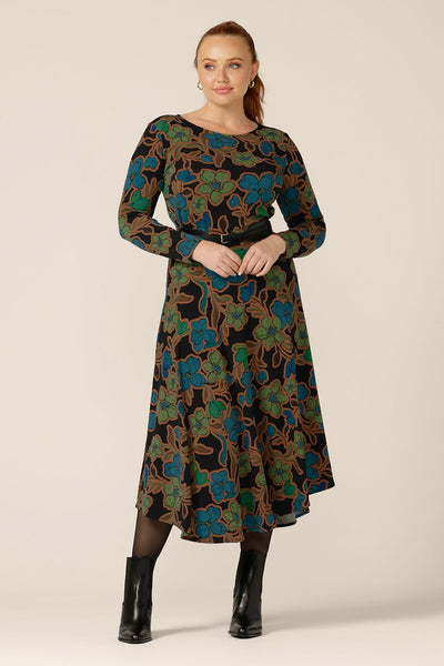 Worn as a faux dress,  a floral print, boat neck top with long sleeves is worn with an asymmetric skirt and black belt. Both are made in Australia by size inclusive women's clothing brand, L&F.